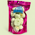 Zielony liofilizowany nugat pistacjowy w torebce Frizle na jasnozielonym pastelowym tle