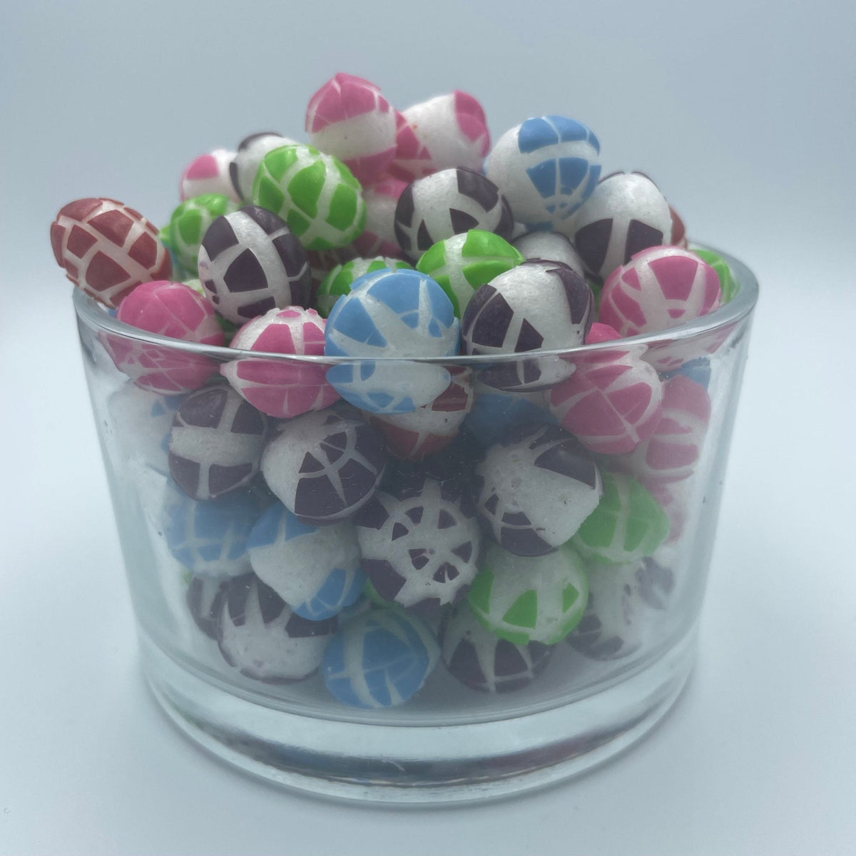 Liofilizowane Skittles Wild Berry w szklanej misce, różowe, czerwone i fioletowe cukierki